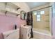Retro bathroom featuring pink tiling, a shower-tub combo, and a vanity sink with classic hardware at 10040 W 13Th Pl, Lakewood, CO 80215