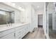 Modern bathroom featuring a double sink vanity, walk-in shower, and wood-look tile flooring at 8245 Butte Creek St, Littleton, CO 80125