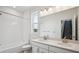 Well-lit bathroom featuring a double sink vanity, a bathtub with shower, and a large mirror at 8245 Butte Creek St, Littleton, CO 80125