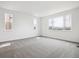 Sunlit bedroom with neutral carpet and windows providing scenic mountain views at 8245 Butte Creek St, Littleton, CO 80125