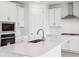 Modern kitchen with white cabinets, stainless steel appliances, quartz countertops, and a center island sink at 8245 Butte Creek St, Littleton, CO 80125