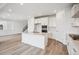 Modern kitchen featuring white cabinets, stainless steel appliances, a center island, and wood floors at 8245 Butte Creek St, Littleton, CO 80125