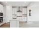 Modern white kitchen featuring stainless steel appliances, a center island, and subway tile backsplash at 8245 Butte Creek St, Littleton, CO 80125