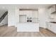 Open-concept kitchen featuring white cabinets, stainless steel appliances, and a center island at 8245 Butte Creek St, Littleton, CO 80125