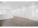 Expansive living room with neutral carpet, modern lighting, and bright white walls at 8245 Butte Creek St, Littleton, CO 80125