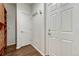 Hallway with hardwood floors, coat hooks, and multiple doors leading to different areas of the house at 17271 Waterhouse Cir # A, Parker, CO 80134