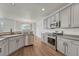 Kitchen with stainless steel appliances, light gray cabinets and hardwood floors overlooking the dining room at 17271 Waterhouse Cir # A, Parker, CO 80134