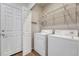 Laundry room with modern appliances, open wire shelving, and access to the rest of the home at 17271 Waterhouse Cir # A, Parker, CO 80134