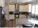 Modern kitchen with stainless steel appliances, white cabinets, and light countertops at 7456 E 10Th Ave, Denver, CO 80230