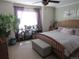 Serene main bedroom with a large window, purple curtains, wooden furniture, and decorative plants at 7456 E 10Th Ave, Denver, CO 80230