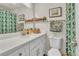 Bright bathroom with white vanity, mirror, and green floral shower curtain at 3163 S Boston Ct, Denver, CO 80231