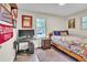 Cozy bedroom featuring a wooden bed frame, a colorful quilt, and a work desk with Harvard décor at 3163 S Boston Ct, Denver, CO 80231