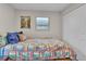 Bedroom showcasing a wooden bed frame with a colorful quilt, a window, and a double-door closet at 3163 S Boston Ct, Denver, CO 80231