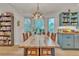 Bright dining room with bay window, light fixture, wood table and hutch at 3163 S Boston Ct, Denver, CO 80231