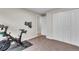 Exercise room with stationary bike on mat, adjacent closet, and brightly-colored hanging garment at 3163 S Boston Ct, Denver, CO 80231