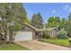 Charming brick home featuring an attached two-car garage and a well-manicured front lawn at 3163 S Boston Ct, Denver, CO 80231