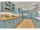 Bright kitchen with blue cabinets, stainless steel appliances, hardwood flooring, and butcher block countertops at 3163 S Boston Ct, Denver, CO 80231