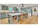 Modern kitchen featuring stylish blue cabinets, hardwood floors, and a kitchen island with barstool seating at 3163 S Boston Ct, Denver, CO 80231