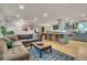 Open-concept living room and kitchen with hardwood floors, gray sofa, and blue kitchen island at 3163 S Boston Ct, Denver, CO 80231