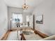 Well-lit bedroom features hardwood floors, white walls, and a charming chandelier at 5990 W 8Th Ave, Lakewood, CO 80214