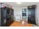 Open kitchen area with black refrigerator, white stove, wood flooring, and view to carpeted living room at 5990 W 8Th Ave, Lakewood, CO 80214