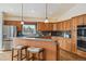Bright kitchen features knotty wood cabinetry, island with seating, and stainless steel appliances at 5990 W 8Th Ave, Lakewood, CO 80214