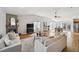Open-concept living room with fireplace, hardwood floors, and dining area with natural light at 5990 W 8Th Ave, Lakewood, CO 80214