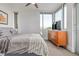 Sunlit bedroom with floor-to-ceiling windows, neutral decor, ceiling fan and a sleek dresser, offering city views at 2758 W 22Nd Ave, Denver, CO 80211