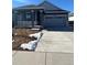 Ranch style home with gray exterior, attached garage, and landscaping at 5127 N Quemoy St, Aurora, CO 80019