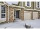 Front entrance of a house with brick and siding, a two-car garage and snowy ground at 223 Durham Ct, Castle Pines, CO 80108