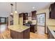 Kitchen with dark wood cabinets, granite island, and stainless steel appliances at 223 Durham Ct, Castle Pines, CO 80108