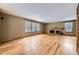 Spacious living room featuring hardwood floors, a brick fireplace, and large windows at 223 Durham Ct, Castle Pines, CO 80108