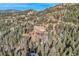 Scenic aerial view of property nestled amongst lush forest; a tranquil mountain retreat at 10197 Crest View Dr, Morrison, CO 80465