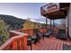 Spacious wooden deck with outdoor seating and views of the surrounding forest at 10197 Crest View Dr, Morrison, CO 80465