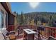 Back deck with comfortable seating around a fire pit overlooking a treed landscape at 10197 Crest View Dr, Morrison, CO 80465