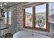 Modern bathroom with a standalone tub, glass shower, and large window showcasing beautiful outdoor views at 10197 Crest View Dr, Morrison, CO 80465