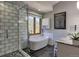 Bright bathroom featuring a soaking tub, glass shower, mountain view, and vanity at 10197 Crest View Dr, Morrison, CO 80465