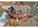 Aerial view highlighting home's expansive deck, hot tub, and beautifully landscaped surroundings at 10197 Crest View Dr, Morrison, CO 80465