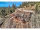 Aerial view of home showcasing its multi-level deck, scenic hillside setting, and wooded surroundings at 10197 Crest View Dr, Morrison, CO 80465
