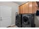 This laundry room has a side-by-side washer and dryer with overhead cabinets, providing ample storage space at 2060 Peralta Loop, Castle Rock, CO 80104