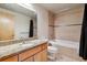 A tiled bathroom featuring a vanity with granite countertop, toilet, and a bathtub with shower at 2900 W 44Th Ave # 301, Denver, CO 80211