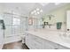 Bright bathroom featuring a glass shower, white cabinets, marble counter, and modern lighting at 3500 S Franklin St, Englewood, CO 80113