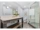A modern bathroom features a marble countertop vanity and a glass-enclosed shower with decorative tile accents at 3500 S Franklin St, Englewood, CO 80113