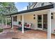 Charming covered patio with brick accents, stylish outdoor seating, and a view of the beautifully landscaped backyard at 3500 S Franklin St, Englewood, CO 80113