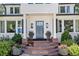Inviting front entrance with stone steps, a gray door, manicured landscaping, and elegant light fixtures at 3500 S Franklin St, Englewood, CO 80113