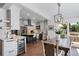 Bright kitchen featuring white cabinetry, stainless steel appliances, an island with bar seating, and adjacent dining area at 3500 S Franklin St, Englewood, CO 80113