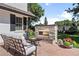 A cozy outdoor living space with a stone fireplace, comfortable seating, and manicured landscaping at 3500 S Franklin St, Englewood, CO 80113