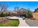 Well-maintained backyard with a curved patio, landscaping, and access to the home's brick exterior at 3345 W Clyde Pl, Denver, CO 80211