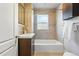 Well-lit bathroom featuring wood-like tiling, modern fixtures, a shower-tub combo, and vanity at 3345 W Clyde Pl, Denver, CO 80211