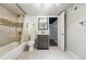 Updated bathroom with a tub, shower, tile and modern vanity at 3345 W Clyde Pl, Denver, CO 80211
